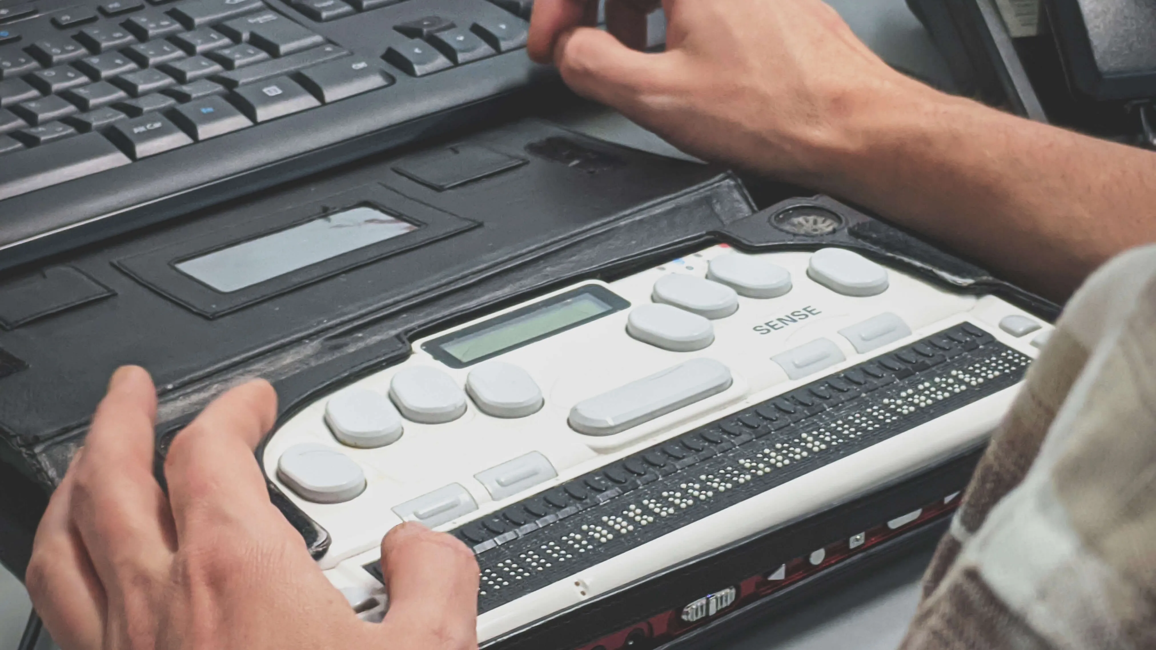 person typing on Braille keyboard